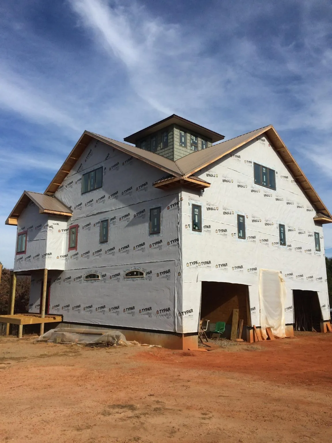 New two story house under construction with a cupola and gabled roofs in Brighton